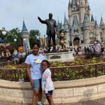 Girl with cerebral palsy in front of Cinderella's Castle at Disney World