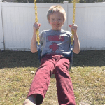 Boy with Down syndrom enjoying his new swing
