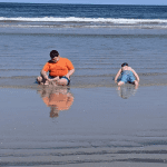 Teen boy with Chiari malformation playing at the beach with younger brother