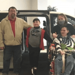 Teen with cerebral palsy in front of new accessible van