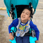 Boy with cerebral palsy enjoying new new adaptive stroller