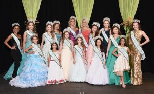 Pageant winners wearing beautiful dresses, sashes, and crowns