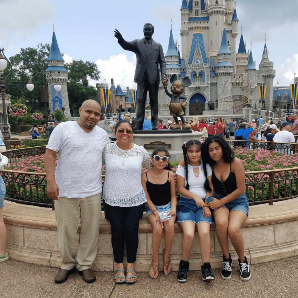 Family smiling in front of Cinderella's Castle at Disney World