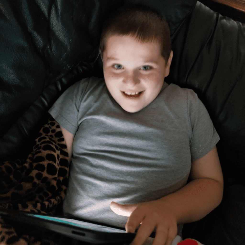 Boy smiling using an iPad