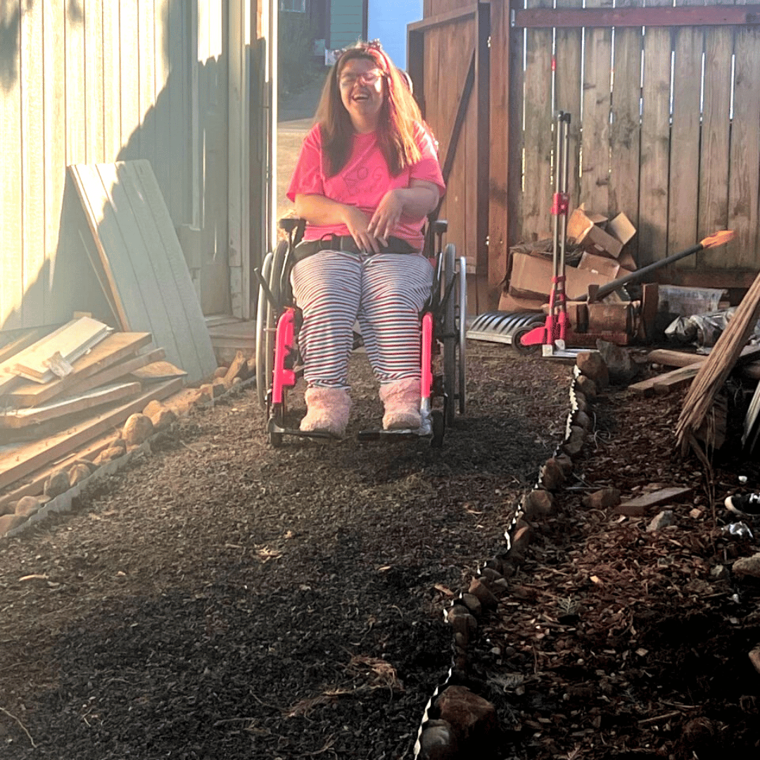 Female smiling in wheelchair on accessible backyard path