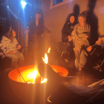 Teens sitting around a campfire