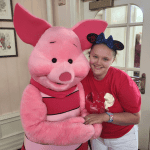Girl with static encephalopathy poses with Piglet at Disney's Crystal Palace