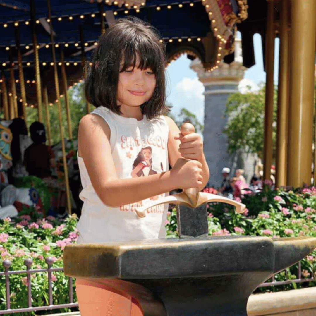 Girl trying to remove the Sword in the Stone at Disney World